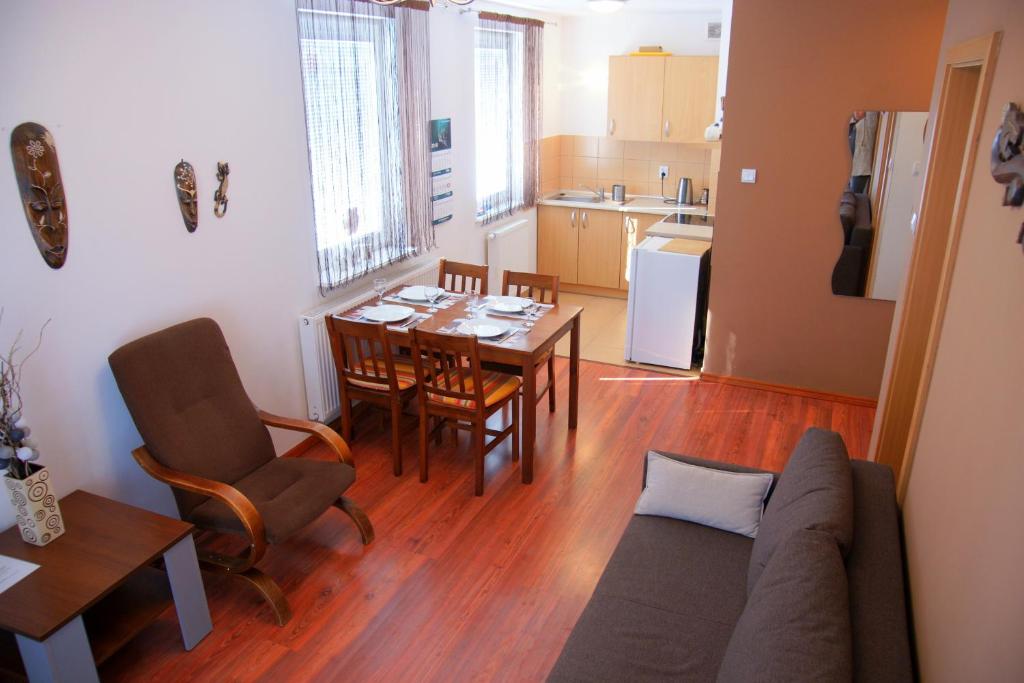 ein Wohnzimmer und eine Küche mit einem Tisch und einem Sofa in der Unterkunft Apartament Słoneczny in Sarbinowo