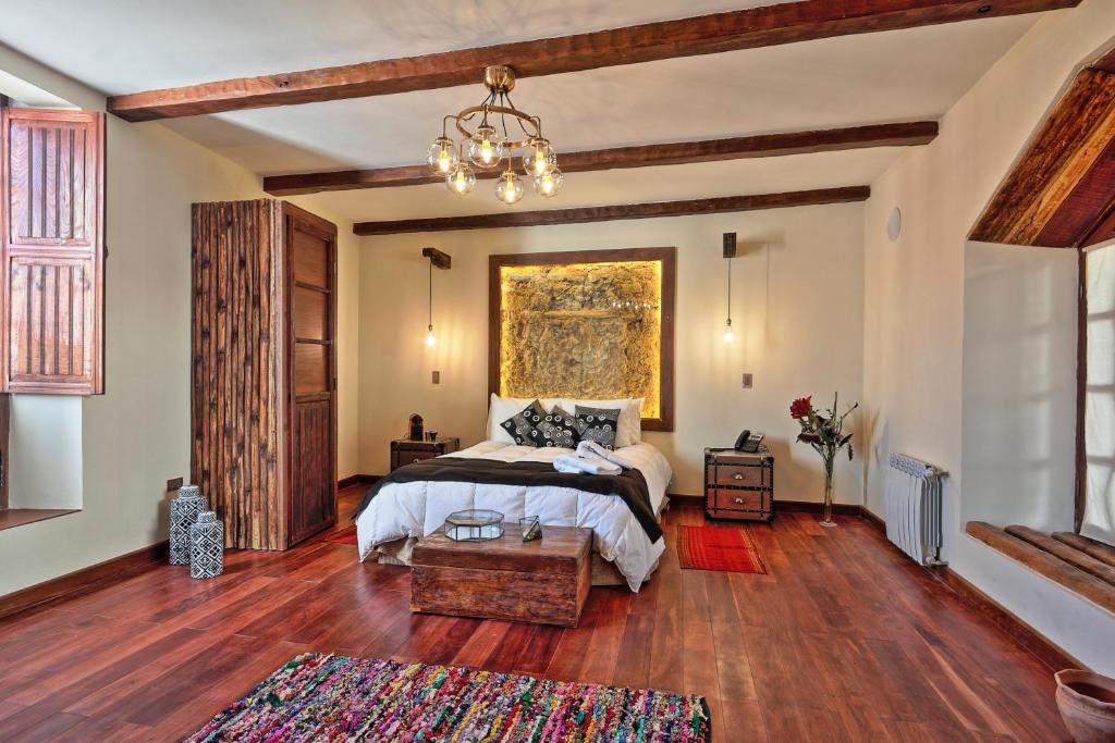 Un dormitorio con una cama y una lámpara de araña. en On Hotel Boutique, en Sucre