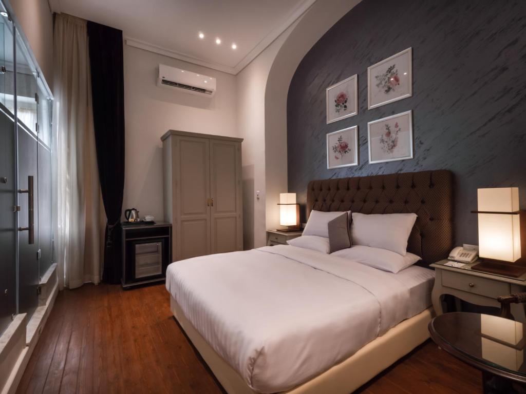 Un dormitorio con una gran cama blanca y dos lámparas. en 1920s Boutique Hotel and Restaurants, en El Cairo