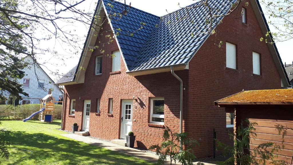 a large red brick house with a solar roof at Ferienhaus "Seestern" in Ostseebad Karlshagen