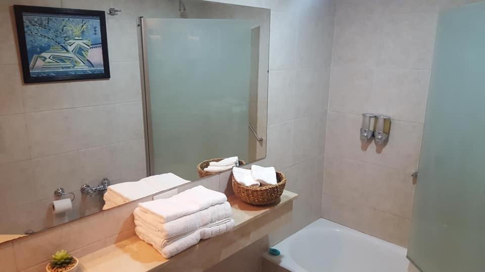 a bathroom with a mirror and towels on a counter at Dg Apart Obelisco in Buenos Aires