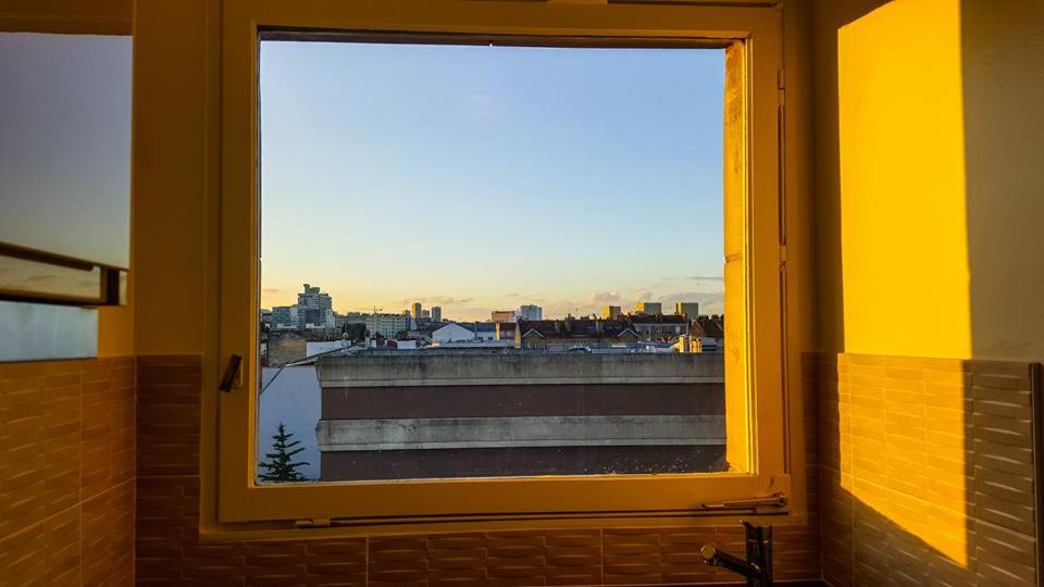 a window in a room with a view of a city at Vue sur Paris in Ivry-sur-Seine