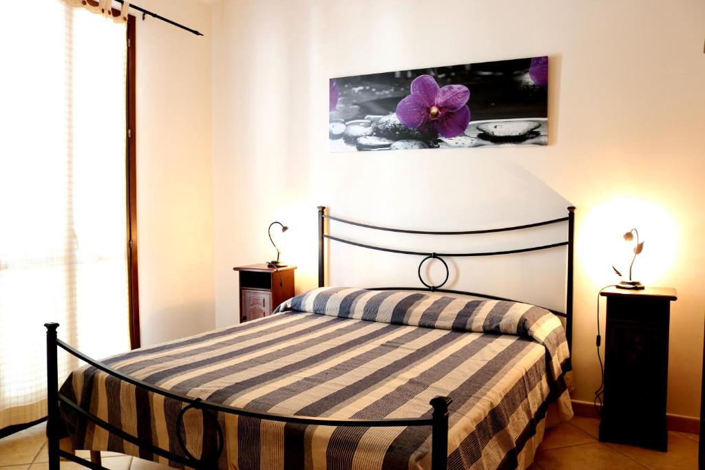サン・ヴィート・ロ・カーポにあるBluvacanze Appartamento Stellaのベッドルーム1室(紫色の花の壁にベッド1台付)