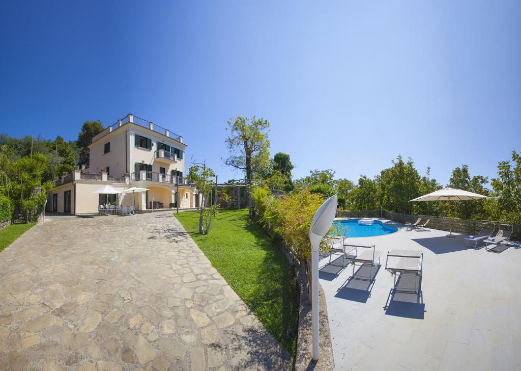 een huis met een zwembad naast een gebouw bij Amore Rentals - Villa Il Noce in SantʼAgata sui Due Golfi