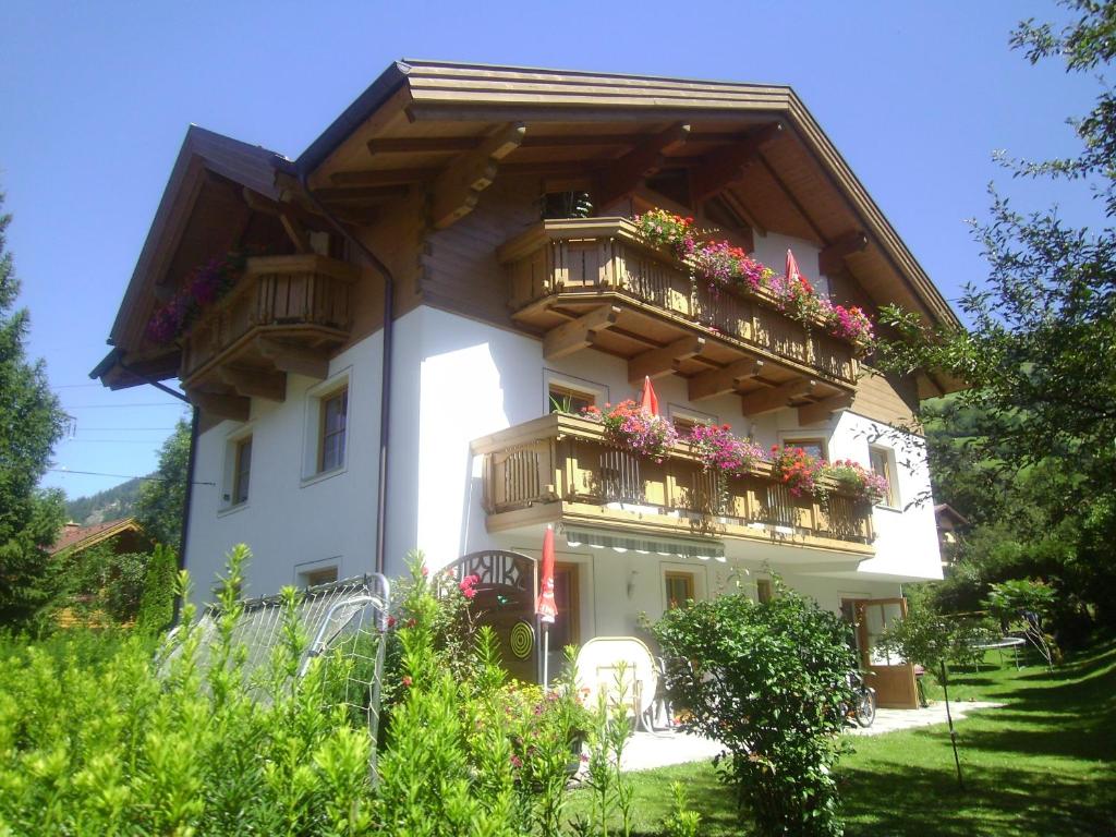 a white building with balconies and flowers on it at Haus Mauberger in Dorfgastein