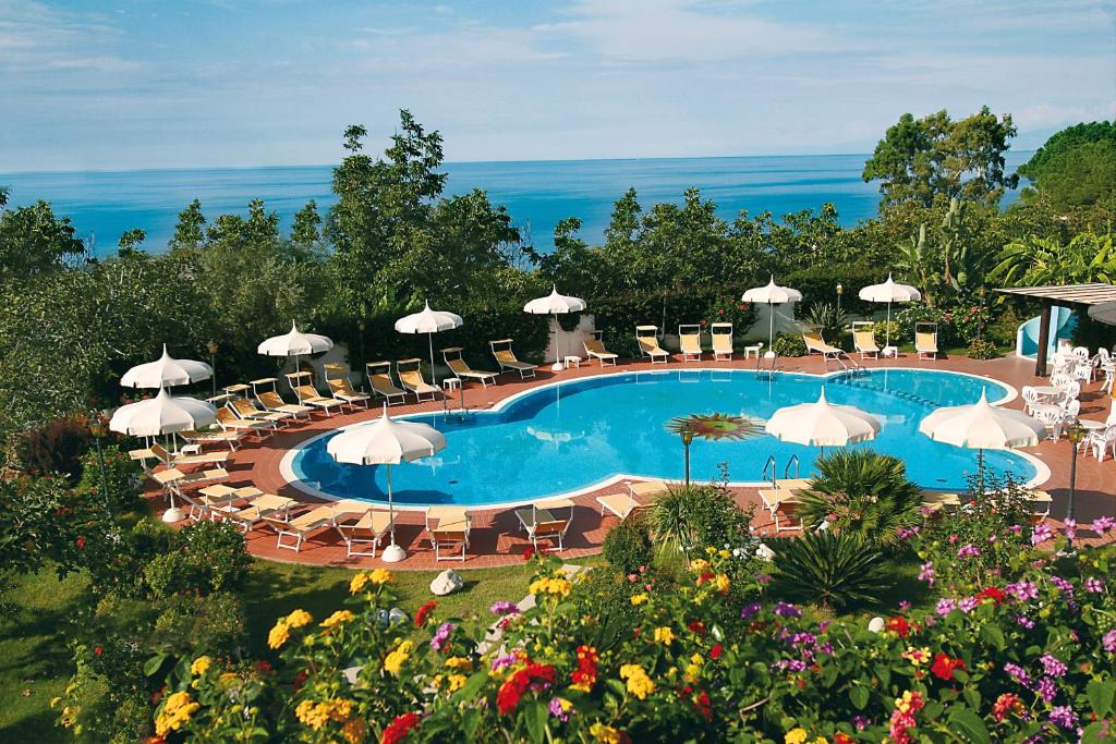 einen Pool mit Stühlen und Sonnenschirmen in der Unterkunft Hotel Tirreno in Parghelia