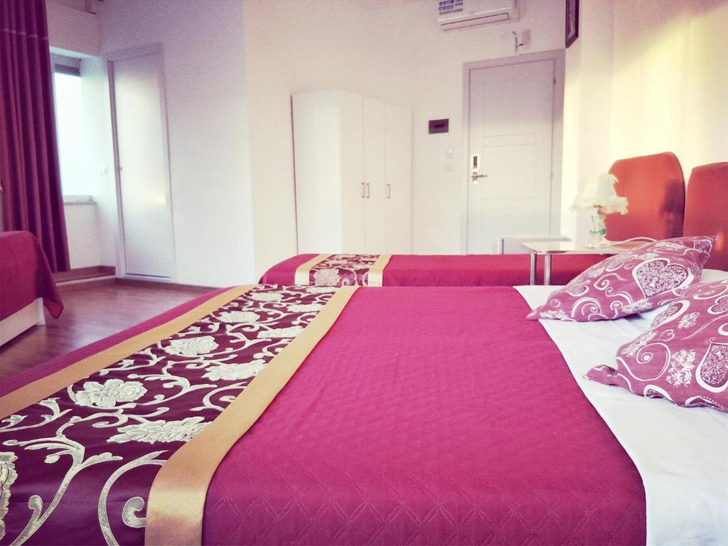 a room with two beds and a table with pillows at Ciclamino Siracusa in Syracuse