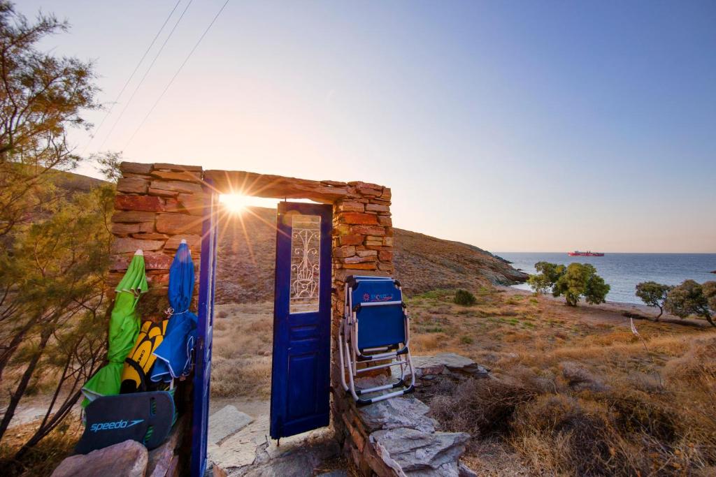 a blue door on a building with the ocean in the background at Amelia Beachfront Villa in Korissia