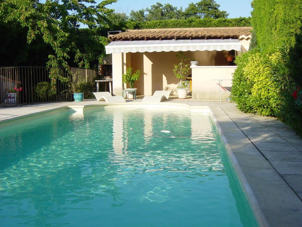 ein Schwimmbad in einem Hof neben einem Haus in der Unterkunft Gite des Taillades in Les Taillades