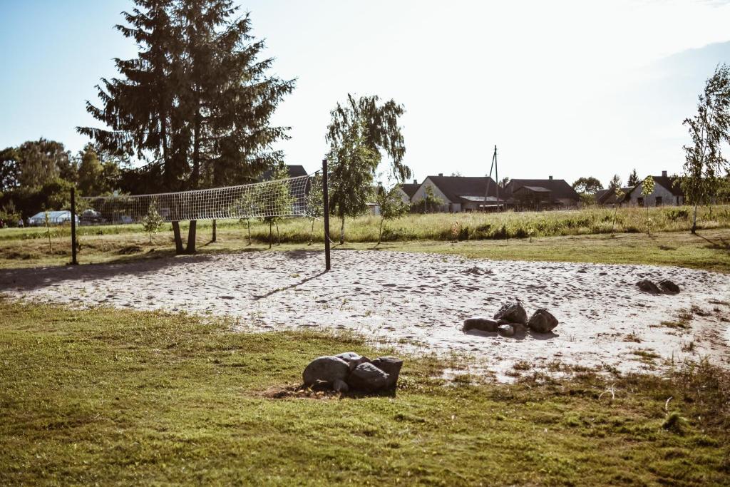 a volleyball net in the middle of a field at Sunny Nights Homestead Rustic House in Gataučiai