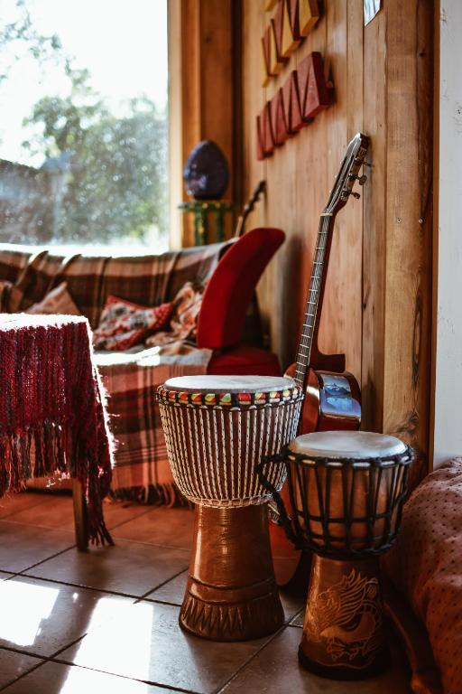 a room with a chair and a guitar in it at Sunny Nights Homestead Rustic House in Gataučiai