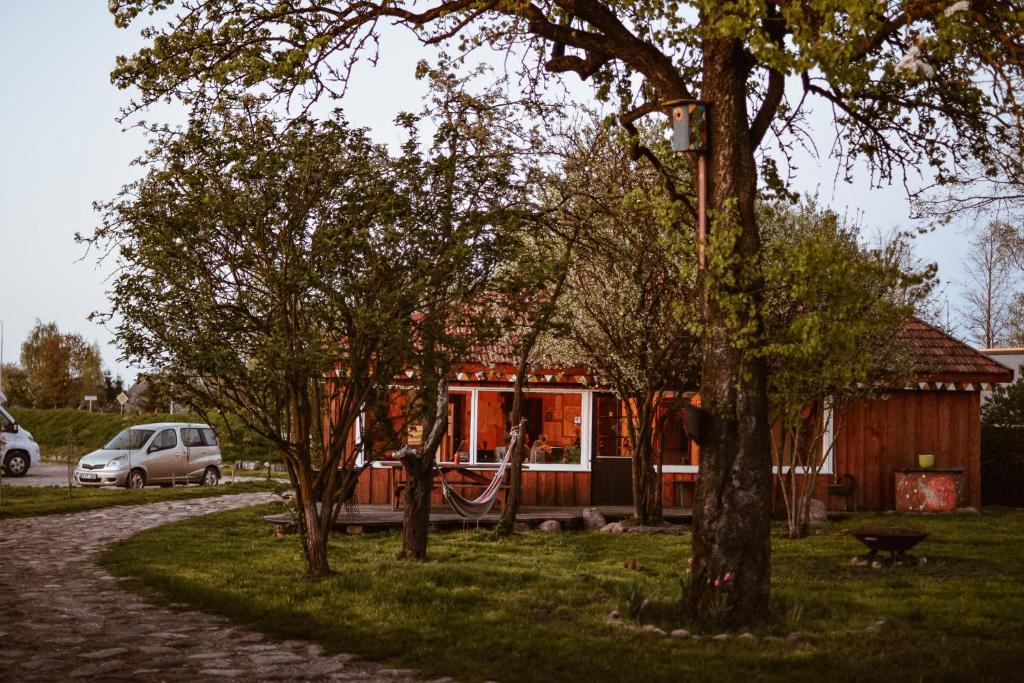 a small house in the middle of some trees at Sunny Nights Homestead Rustic House in Gataučiai