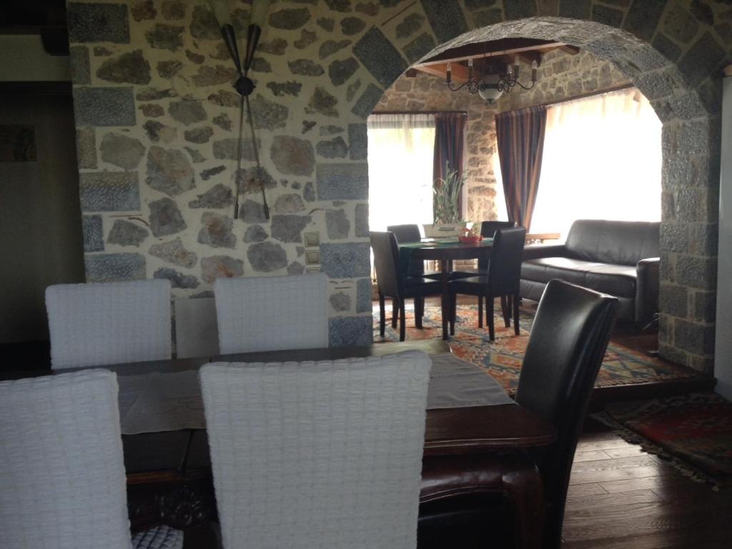 uma sala de estar com uma mesa e cadeiras e uma parede de pedra em Mountain Villa em Graviá