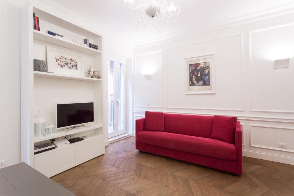 uma sala de estar com um sofá vermelho e uma televisão em Be Home Rome em Roma