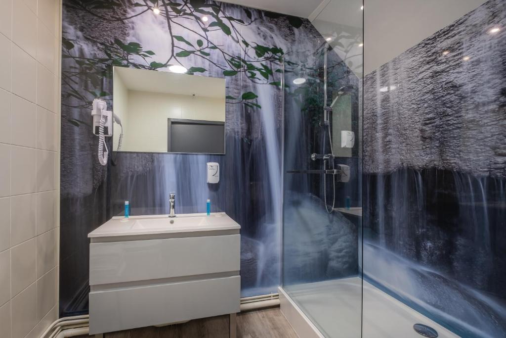 W łazience znajduje się umywalka i prysznic. w obiekcie Grand Hôtel du Luxembourg & Spa w mieście Bayeux