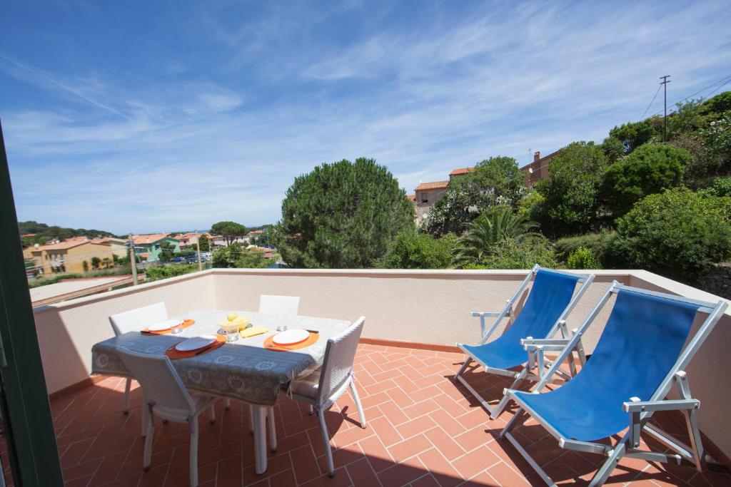 un patio con tavolo e sedie sul balcone. di Villetta il Gelsomino a Marciana Marina