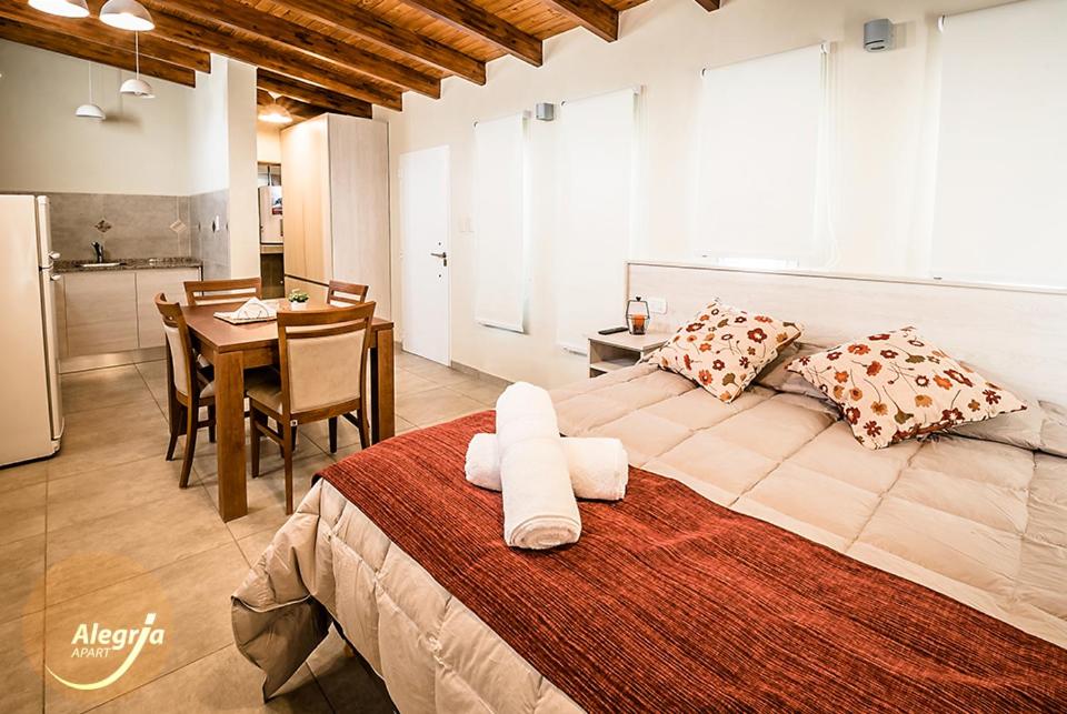 a large bedroom with a large bed and a kitchen at Alegria Apart in San Rafael