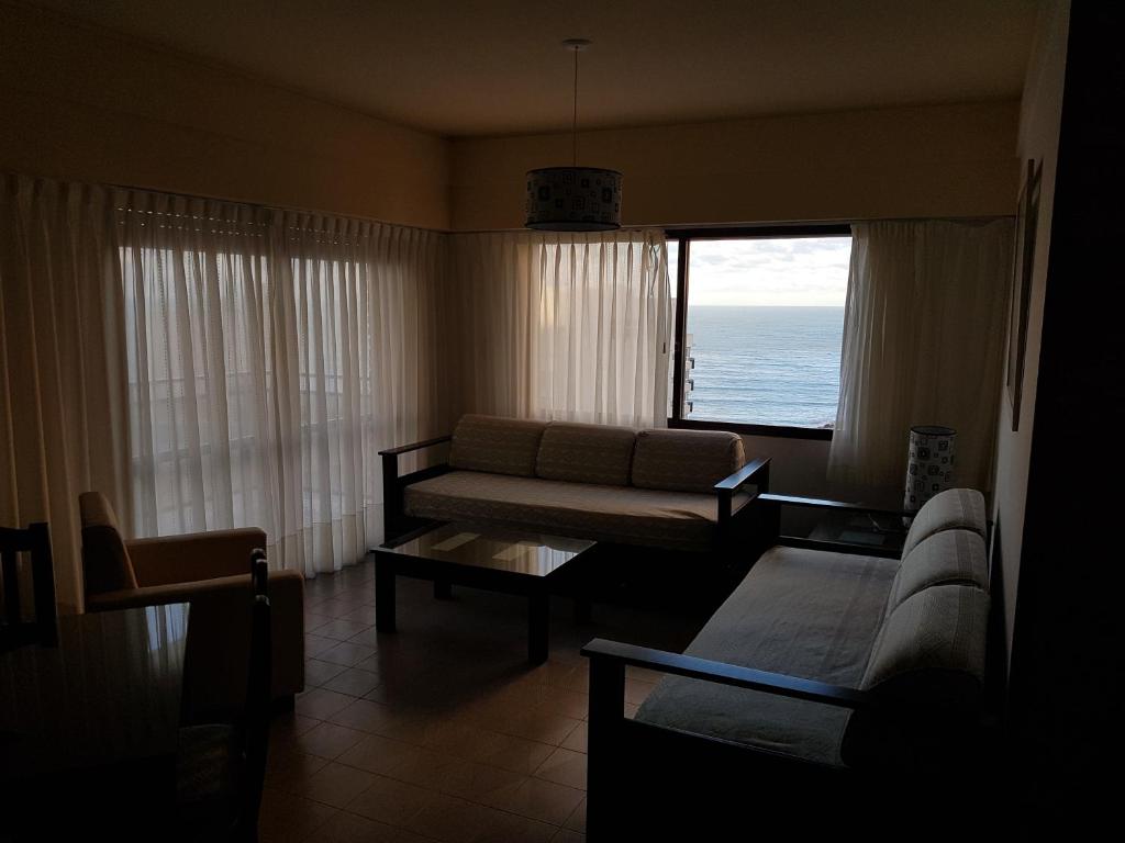 a living room with a couch and a view of the ocean at Club Sol Mar Del Plata in Mar del Plata