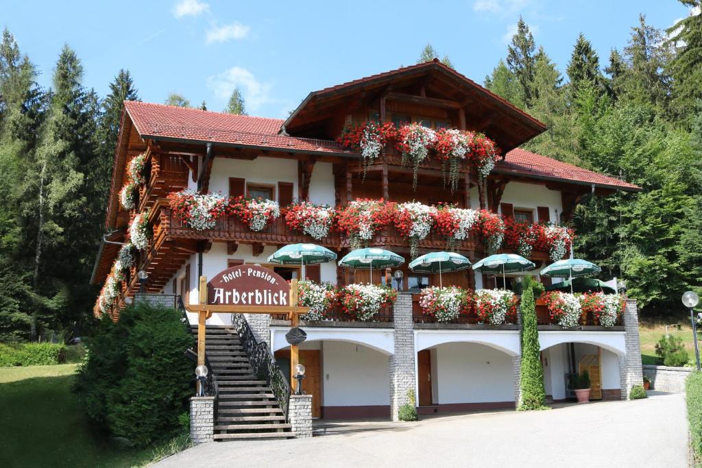 a building with flowers and umbrellas on it at GarniHotel - Arberblick in Lohberg