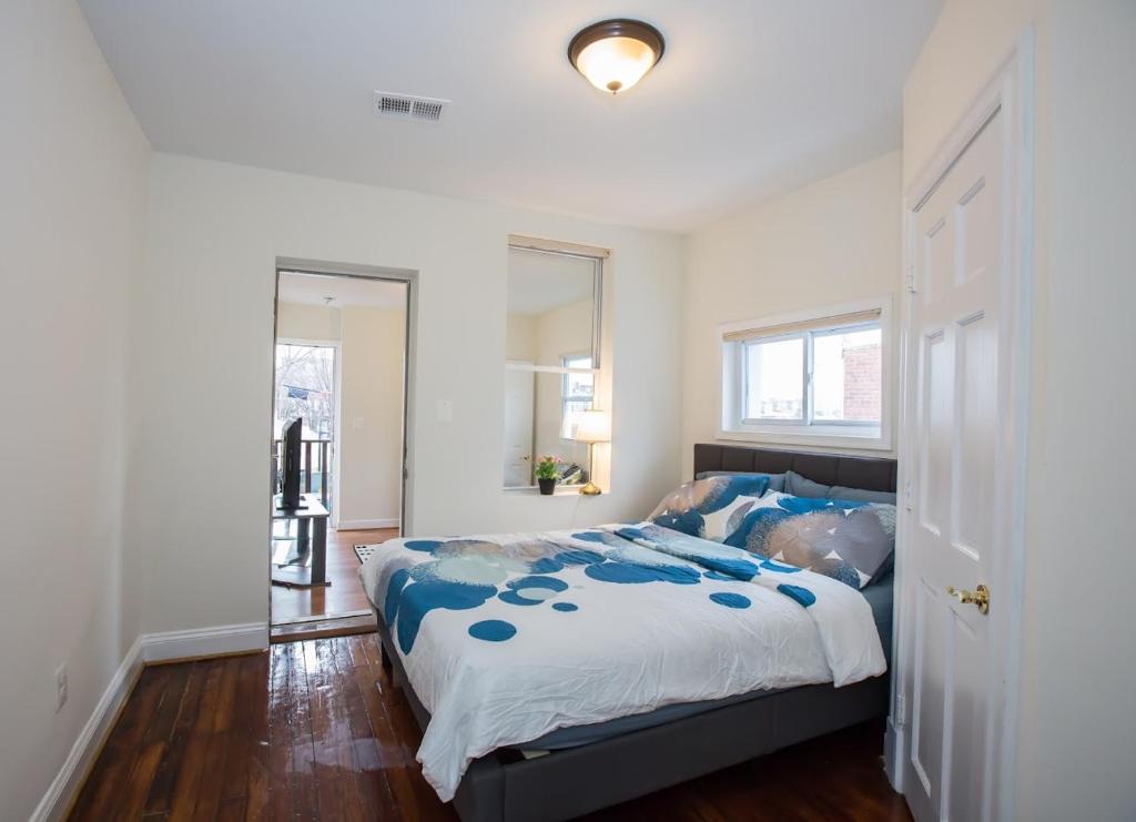 a bedroom with a bed with a blue comforter at Charming studio - 3 min walk to PETWORTH Metro station; 10 min to Convention Center in Washington, D.C.