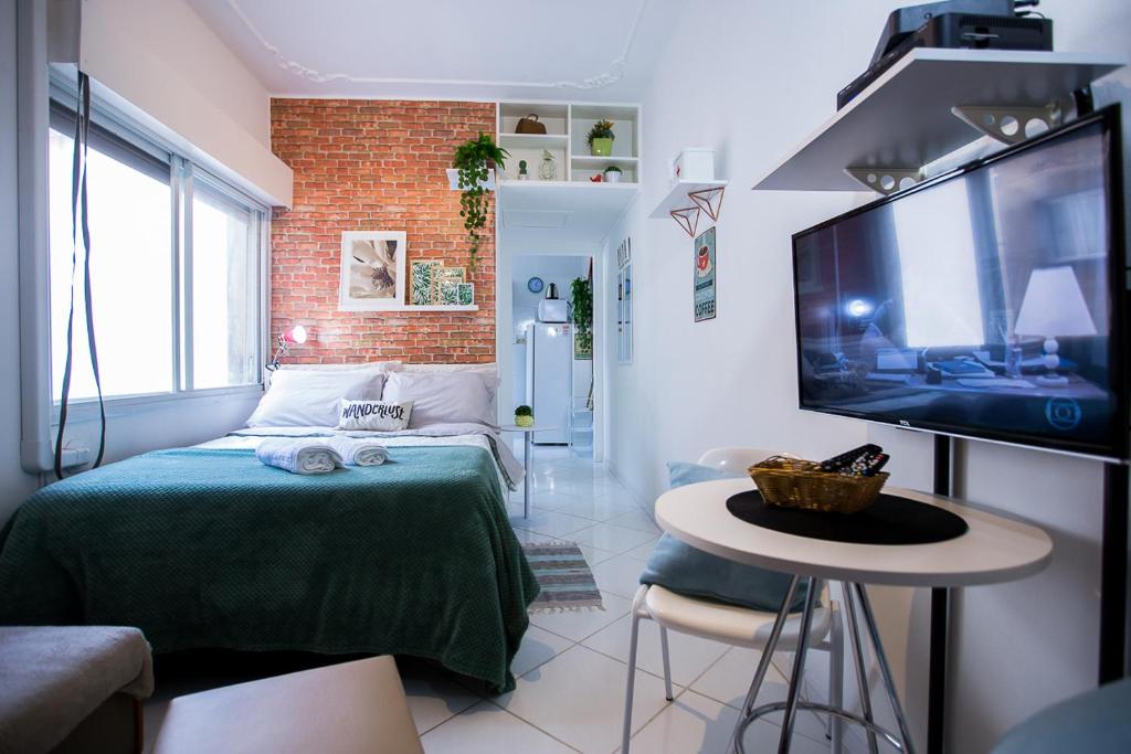 Habitación pequeña con cama y TV. en Sossego na Cidade Baixa en Porto Alegre