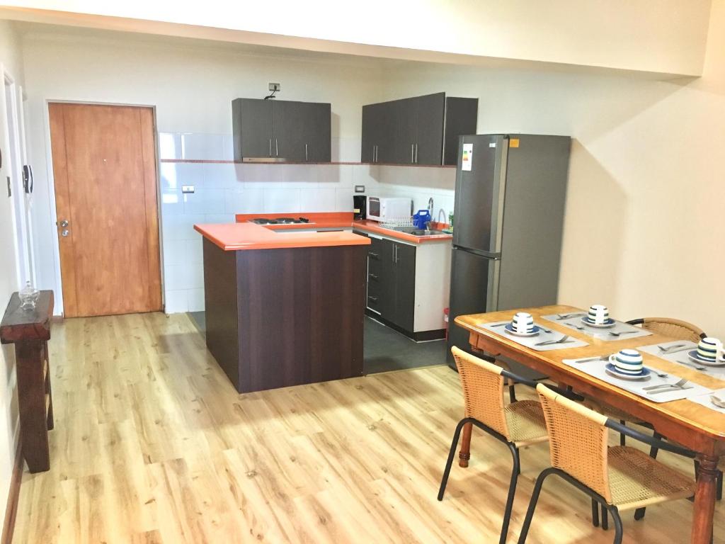 una pequeña cocina con mesa y una cocina con mesa y sillas. en Departamento completo 42 mts2 - 2 habs y 1 futón - Centro Tomé - 5 personas max - Edificio Don Francisco, en Tomé