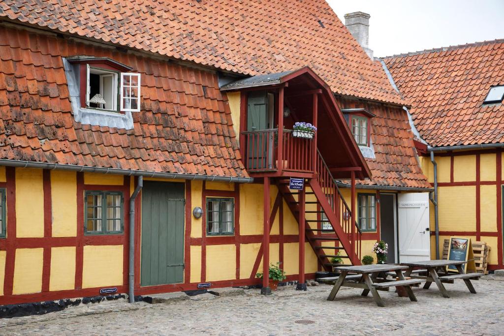 um edifício com uma escada e uma mesa e banco em Købmandsgårdens B&B Kerteminde em Kerteminde