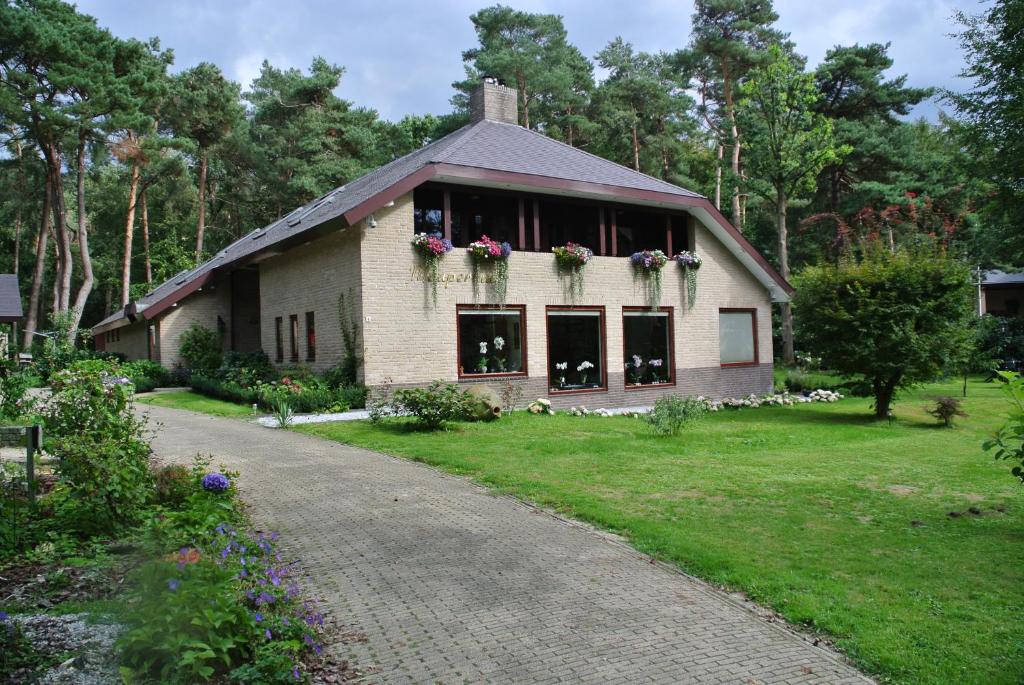 a house with flower boxes on the windows and a driveway at Maupertuus Bennekom in Bennekom