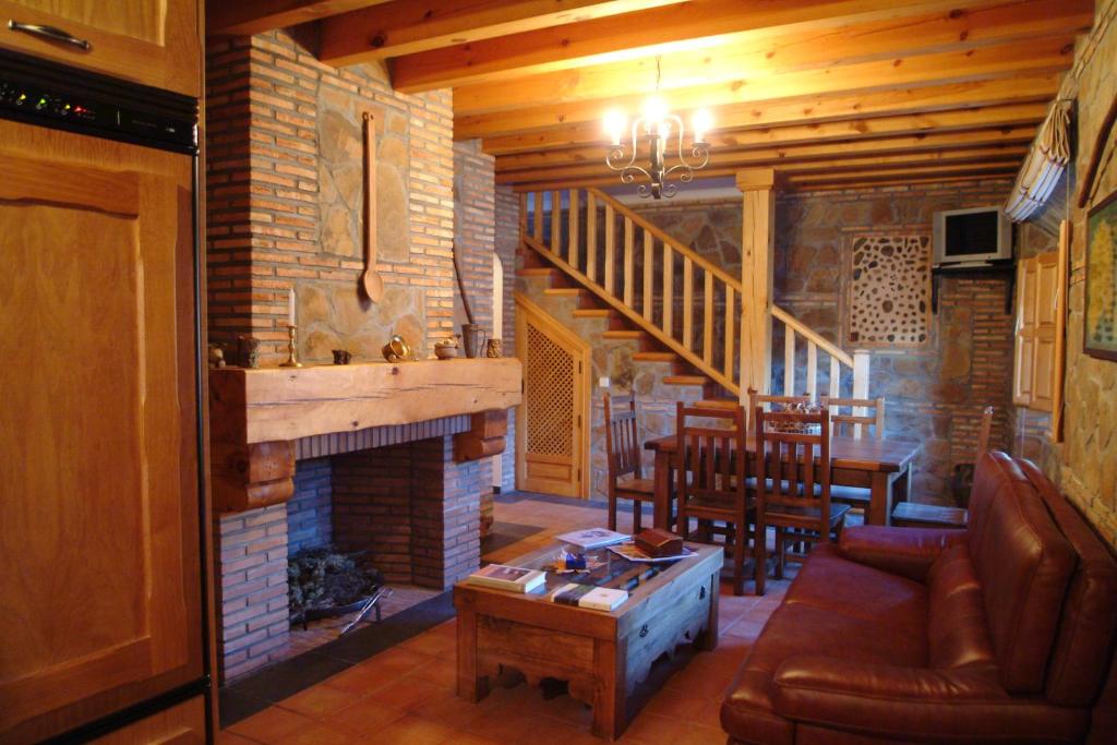 sala de estar con sofá y chimenea en Casa Rural María Victoria, en Navas de Estena