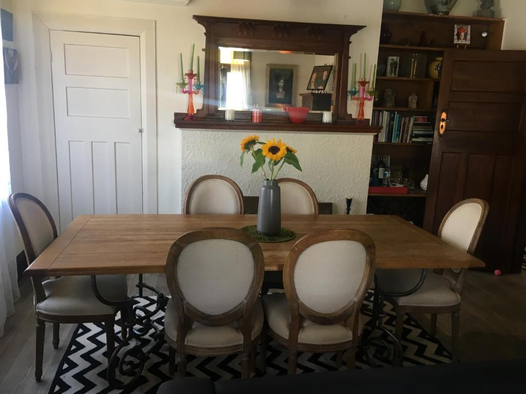a dining room table with chairs and a vase of flowers at The Inn At The Convent in Taumarunui