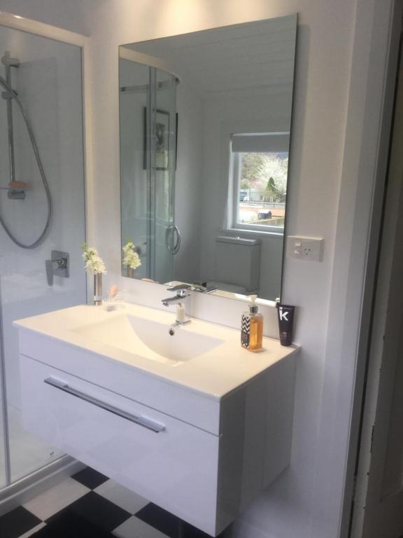 a bathroom with a white sink and a mirror at The Inn At The Convent in Taumarunui