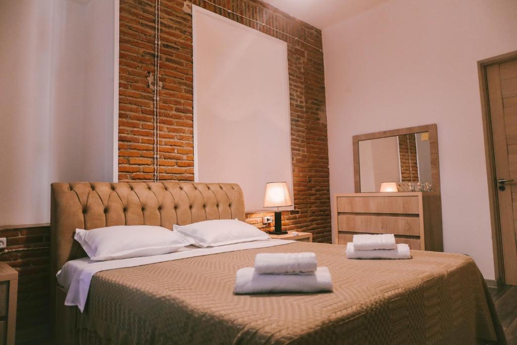 1 dormitorio con 1 cama con 2 toallas en Old Chache House, en Telavi