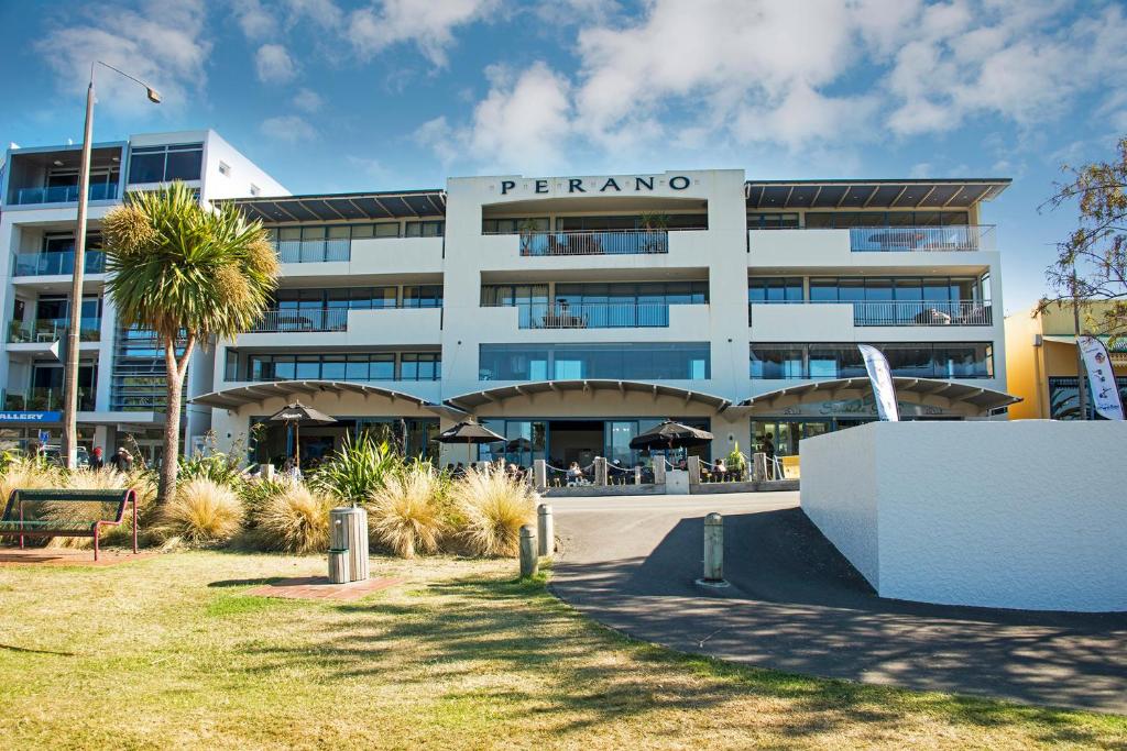 a large building with a palm tree in front of it at Perano on the Quay in Picton