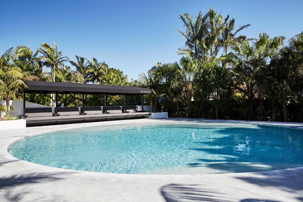 a swimming pool with a gazebo and trees at The Bower Byron Bay in Byron Bay