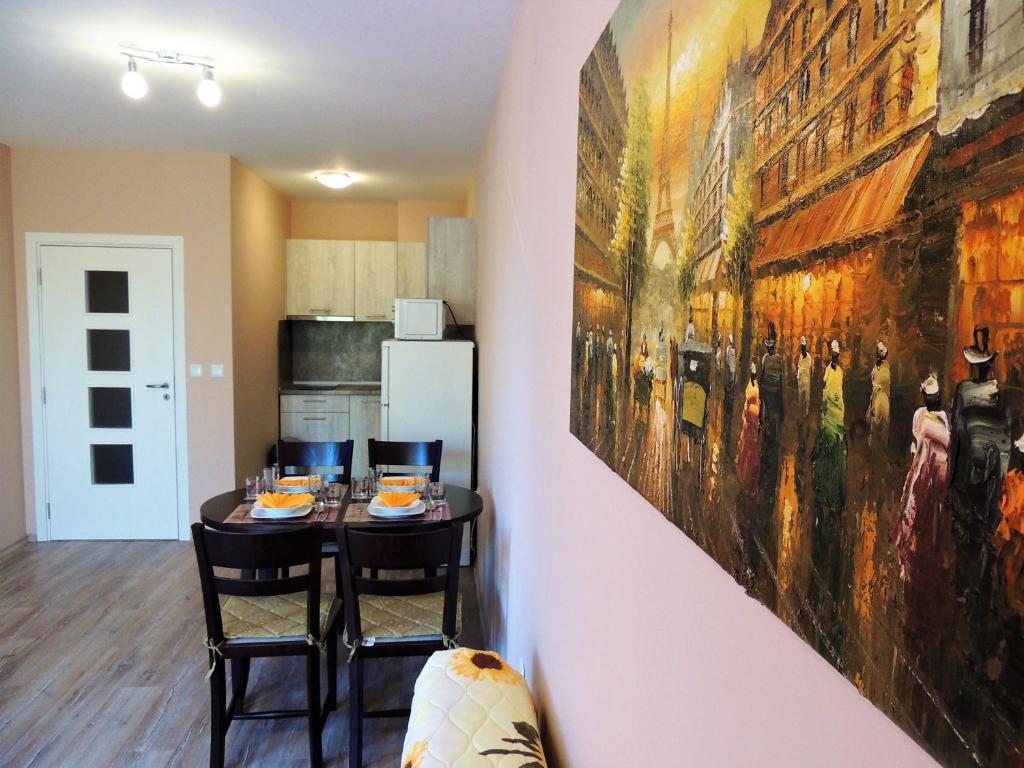 una cocina con mesa y una gran pintura en la pared en Хисаря ВИП апартаменти en Hisarya