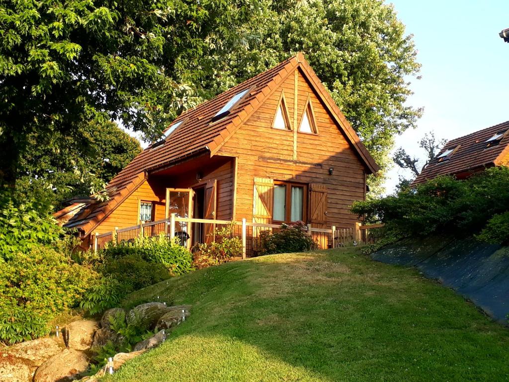 una casa de madera en una colina con patio en Lake Dathee Lodge, en Vire