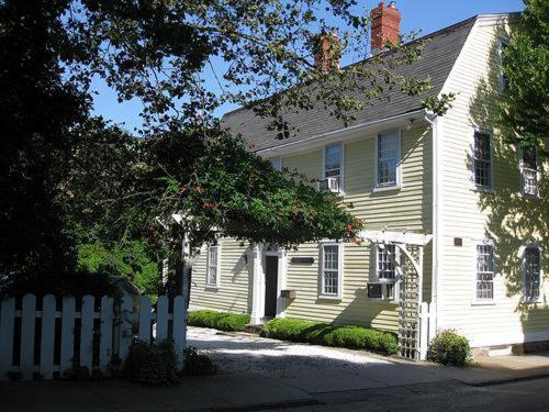 a white house with a white fence in front of it at Admiral Farragut Inn in Newport