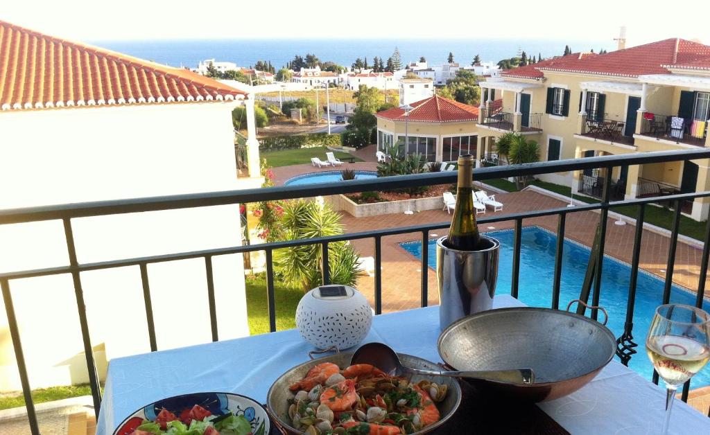 uma mesa com uma tigela de comida e um copo de vinho em Vista Bonita Algarve em Porches