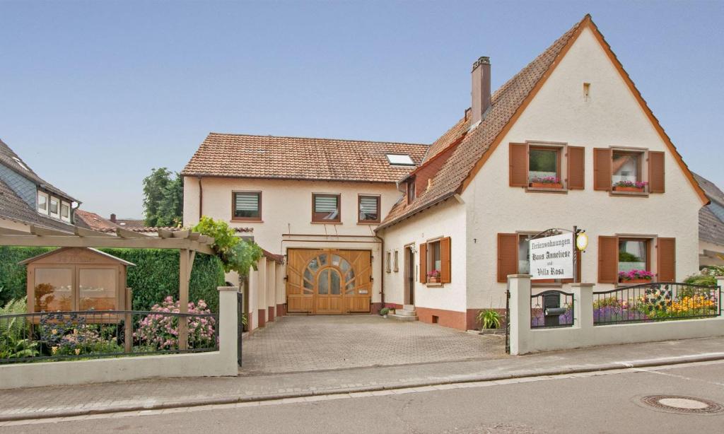 een groot wit huis met een houten garage bij Ferienwohnungen Anneliese in Neustadt an der Weinstraße