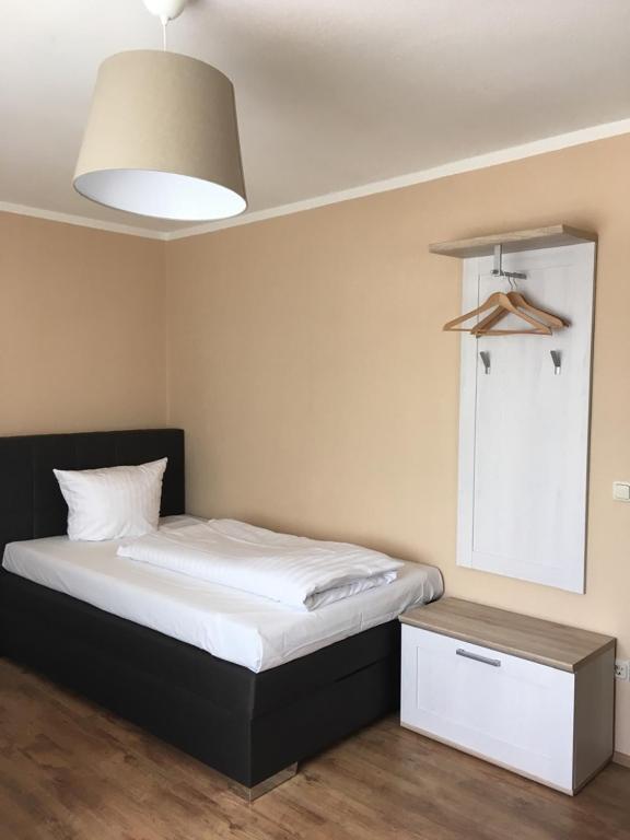 a bedroom with a bed with a black headboard and a table at Hotel-Residenz Oberurseler Hof in Oberursel