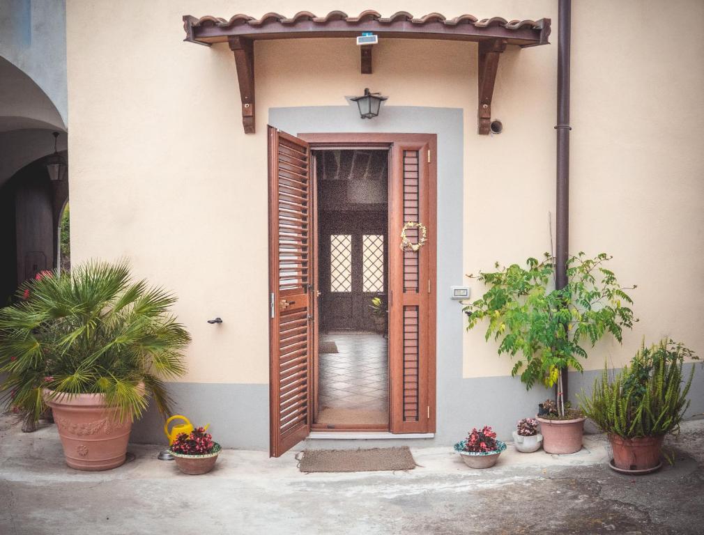 uma porta da frente de uma casa com vasos de plantas em B&b A casa di Maybe em Caserta