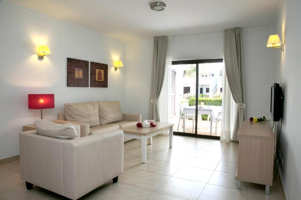 a living room with a white couch and a table at Sagres Time Apartamentos in Sagres