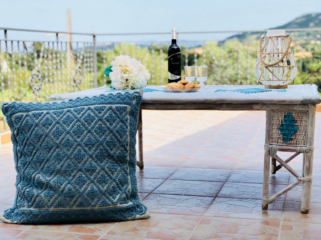 un tavolo con una bottiglia di vino e una sedia di Appartamento Leda a Piras
