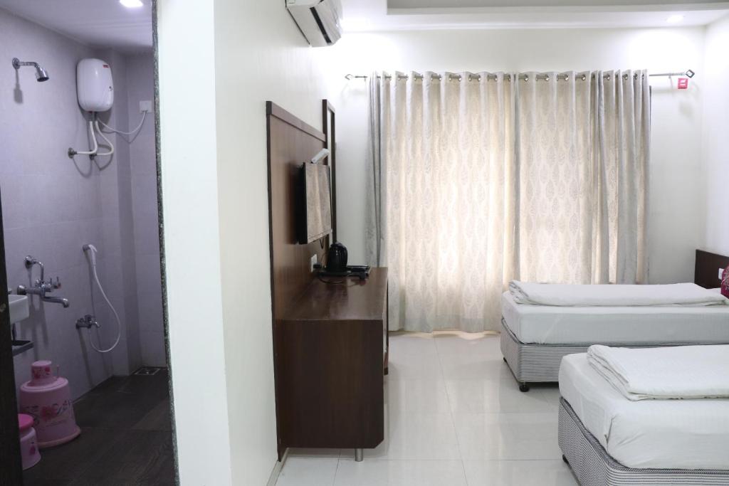 Postel nebo postele na pokoji v ubytování Hotel Sai Shubham
