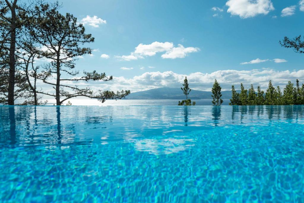 een zwembad met uitzicht op een meer bij Atlantic Heritage Luxury Villa in Madalena