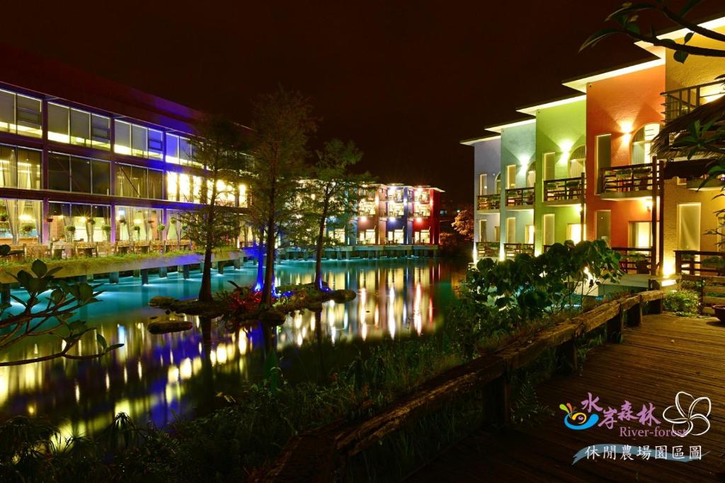 a building with a pool of water at night at River Forest Leisure Farm in Dongshan