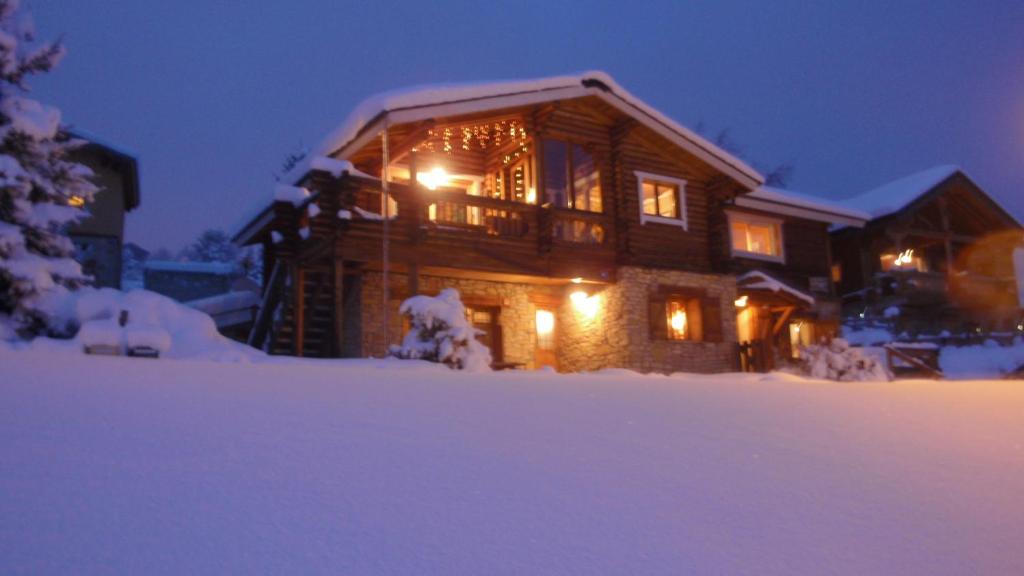 a log cabin in the snow at night at Appartements dans Chalet in Font-Romeu