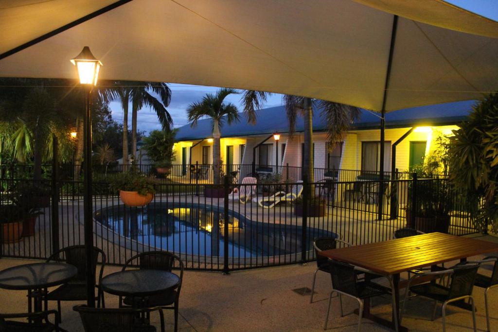 un patio con tavolo, sedie e piscina di Peppercorn Motel a Clermont