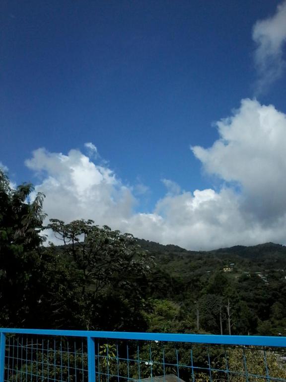 valla azul con vistas a la montaña en Cabinas Nuestra Kasa, en Monteverde