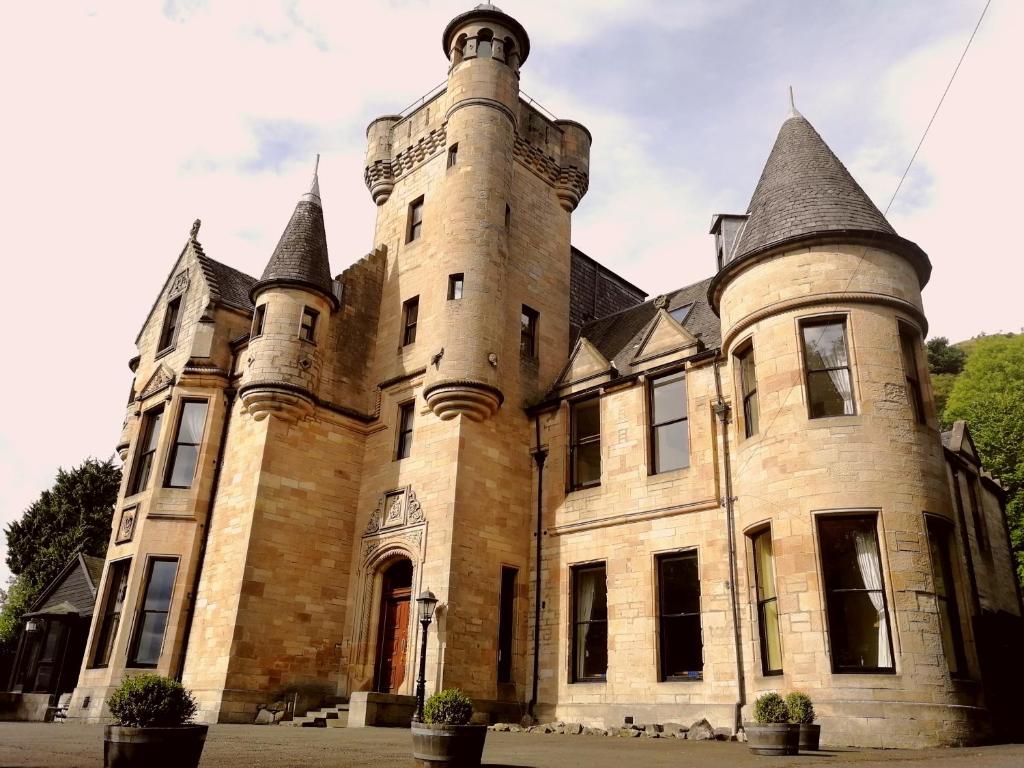 un viejo castillo con dos torres encima. en Broomhall Castle Hotel en Stirling